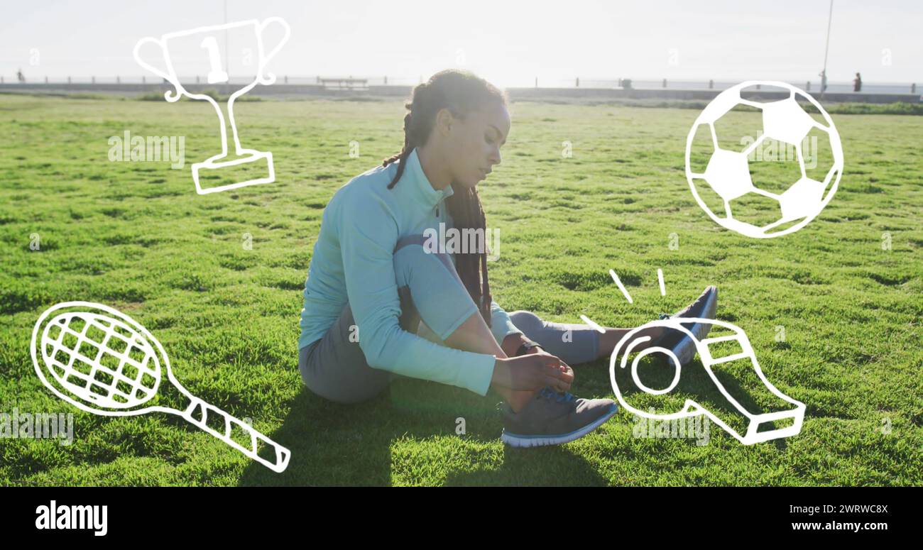 Icone del concetto sportivo contro una donna afroamericana che lega i lacci delle scarpe seduti sull'erba Foto Stock