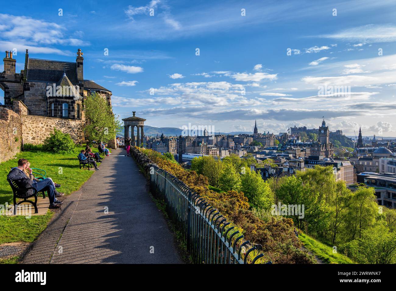 Edimburgo, Scozia, Regno Unito - 9 maggio 2023: Le persone si rilassano sulla Calton Hill al tramonto con vista sul centro storico della città. Foto Stock