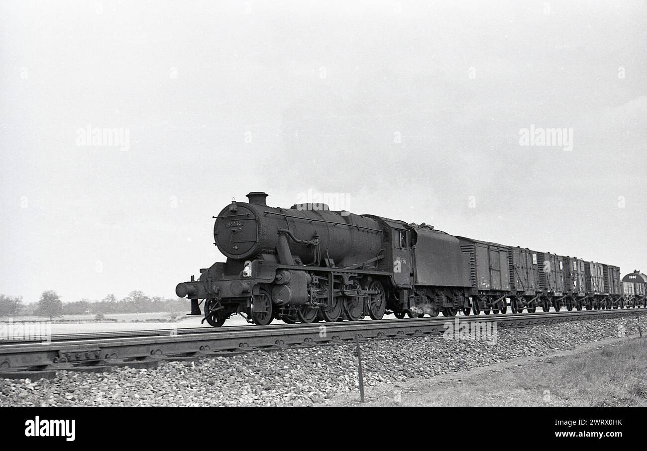 1950, storica, una locomotiva a vapore con carri merci su binario ferroviario, una British Railways Stanier 8F 2-8-0 48436, Inghilterra, Regno Unito. Foto Stock