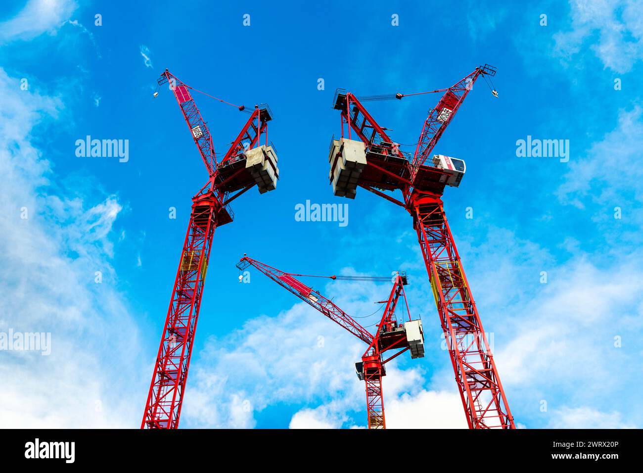 Gru da costruzione rosse contro il cielo blu, Londra, Regno Unito Foto Stock