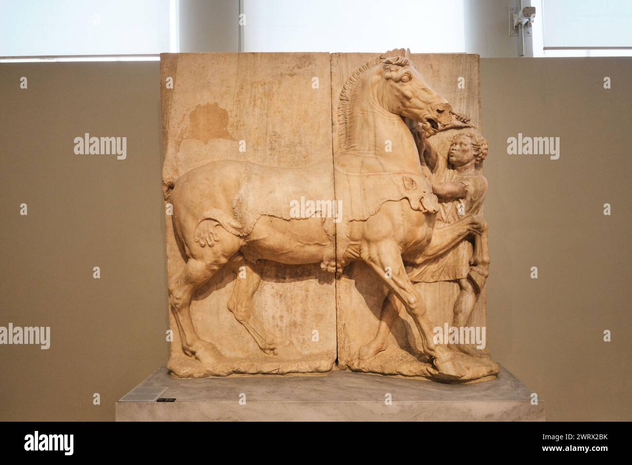 Atene, Grecia - 3 marzo 2024: Stele funerarie raffiguranti un cavallo e il suo sposo etiope (4° sec. B.C.) presso il Museo Archeologico Nazionale Foto Stock
