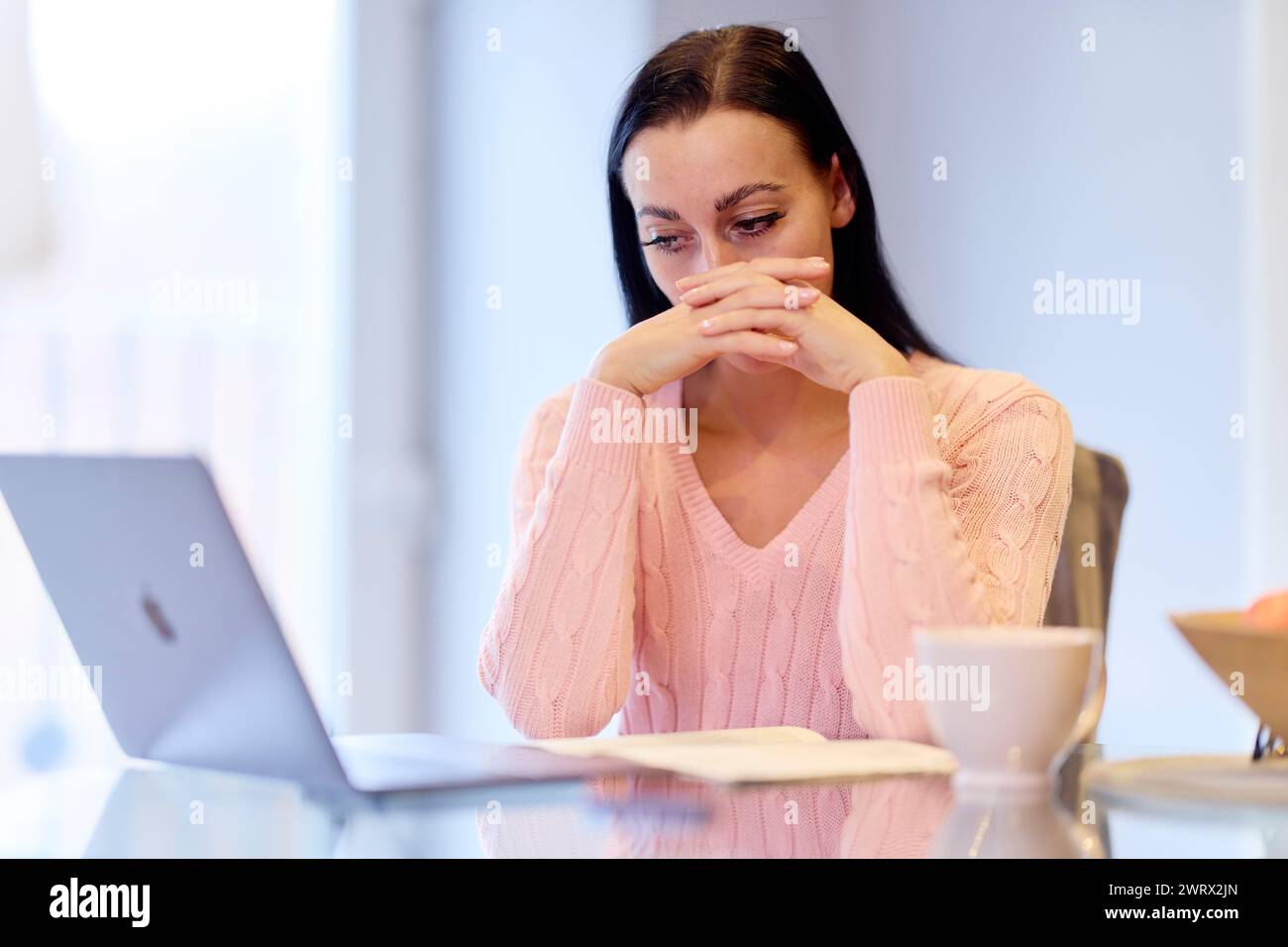 Donna preoccupata che guarda le sue fatture Foto Stock