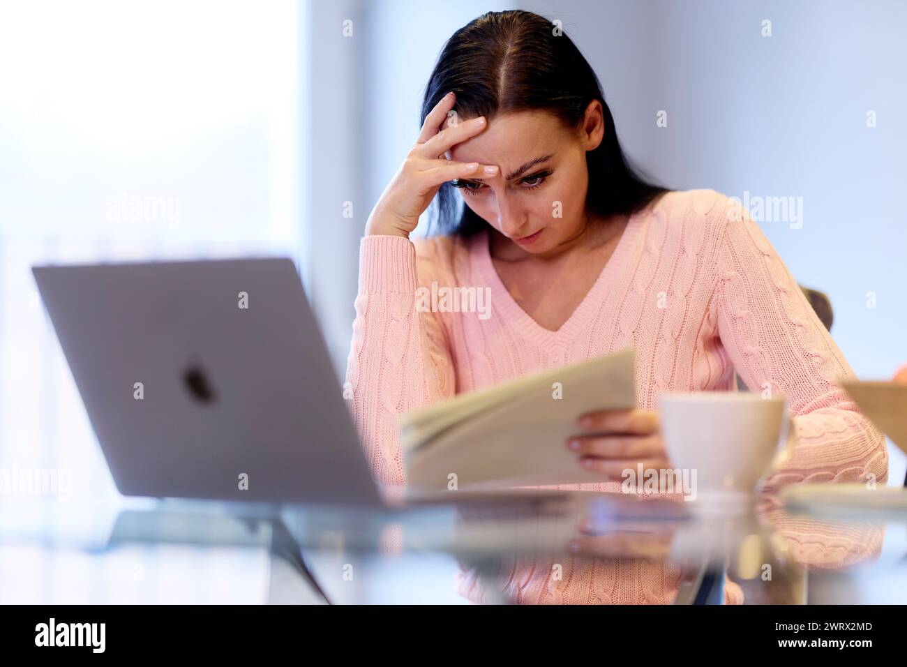 Donna preoccupata che guarda le sue fatture Foto Stock