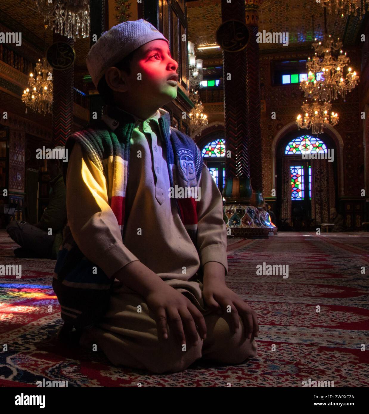 Srinagar, Kashmir, India. 14 marzo 2024. Un ragazzo musulmano del Kashmir viene visto all'interno di un santuario mentre posa per una foto il terzo giorno del mese islamico del Ramadan a Srinagar. Il Ramadan è il nono mese del calendario islamico e ha un significato speciale nell'Islam. I musulmani credono che durante questo mese, i primi versi del Corano, il libro sacro dell'Islam, siano stati rivelati al profeta Maometto. (Credit Image: © Adil Abbas/ZUMA Press Wire) SOLO PER USO EDITORIALE! Non per USO commerciale! Foto Stock