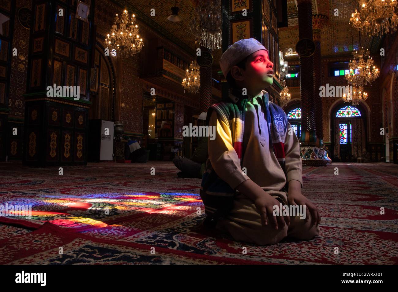Srinagar, Kashmir, India. 14 marzo 2024. Un ragazzo musulmano del Kashmir viene visto all'interno di un santuario il terzo giorno del mese islamico del Ramadan a Srinagar. Il Ramadan è il nono mese del calendario islamico e ha un significato speciale nell'Islam. I musulmani credono che durante questo mese, i primi versi del Corano, il libro sacro dell'Islam, siano stati rivelati al profeta Maometto. (Credit Image: © Adil Abbas/ZUMA Press Wire) SOLO PER USO EDITORIALE! Non per USO commerciale! Foto Stock