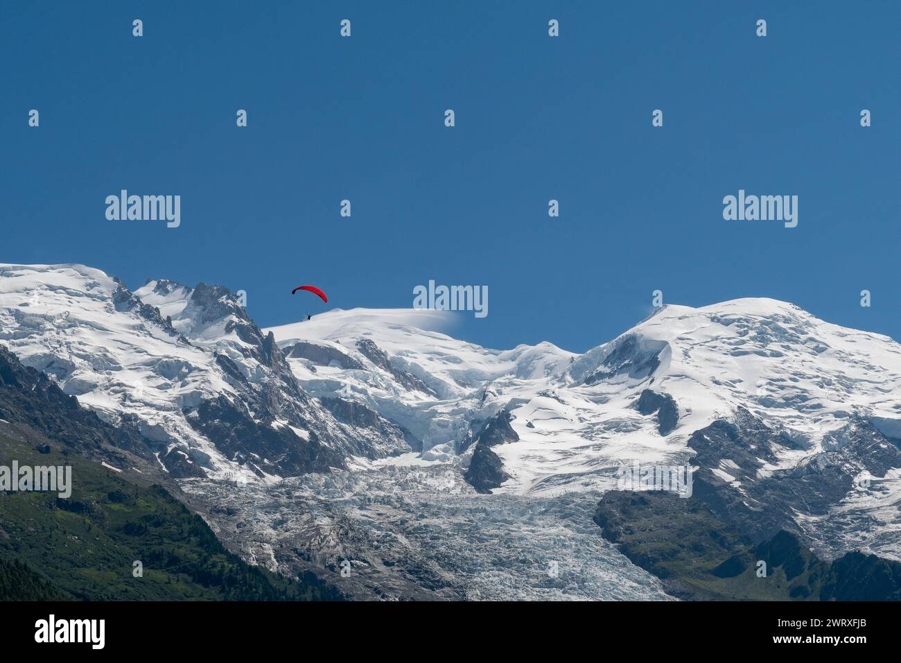 Vista del Monte bianco (4805 m), la montagna più alta d'Europa, con un parapendio rosso in estate, Chamonix, alta Savoia, Francia Foto Stock