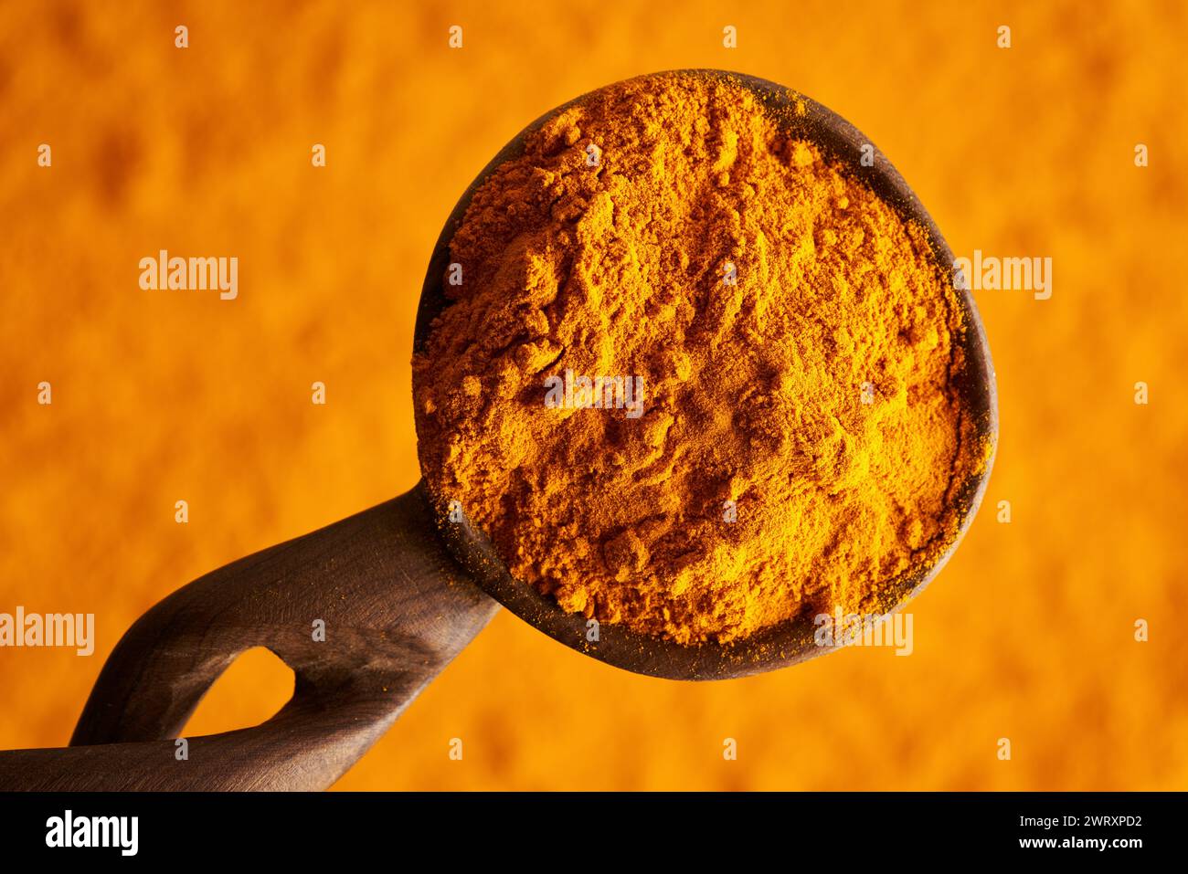 Polvere di radice di curcuma arancione su un cucchiaio, vista dall'alto Foto Stock