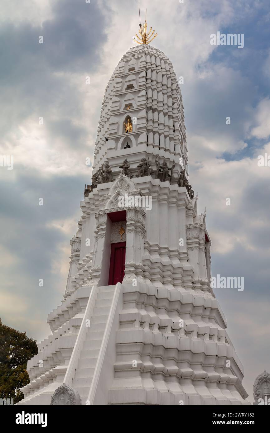 Prang bianco al Wat Rakhang, Bangkok, Thailandia. Decorata con sculture marroni e dorate. Cielo blu nuvoloso sullo sfondo. Foto Stock