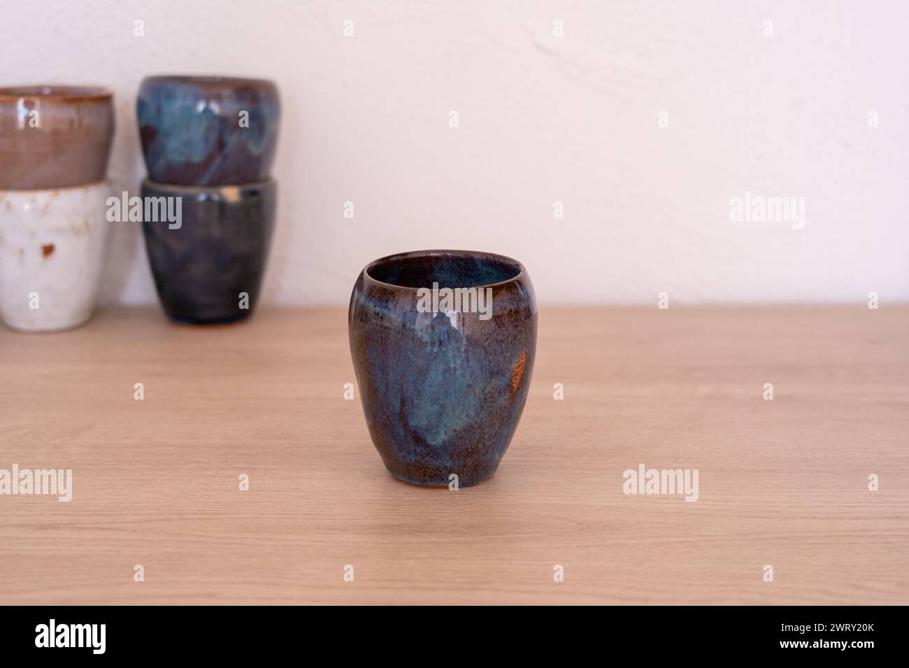 Tazza colorata fatta a mano su un tavolo di legno. Foto di alta qualità Foto Stock
