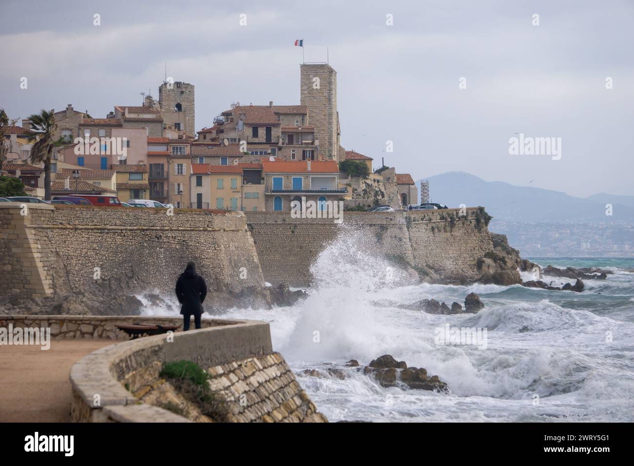 Uomo che guarda la tempesta, la città vecchia, le onde, Antibes. Foto di alta qualità Foto Stock