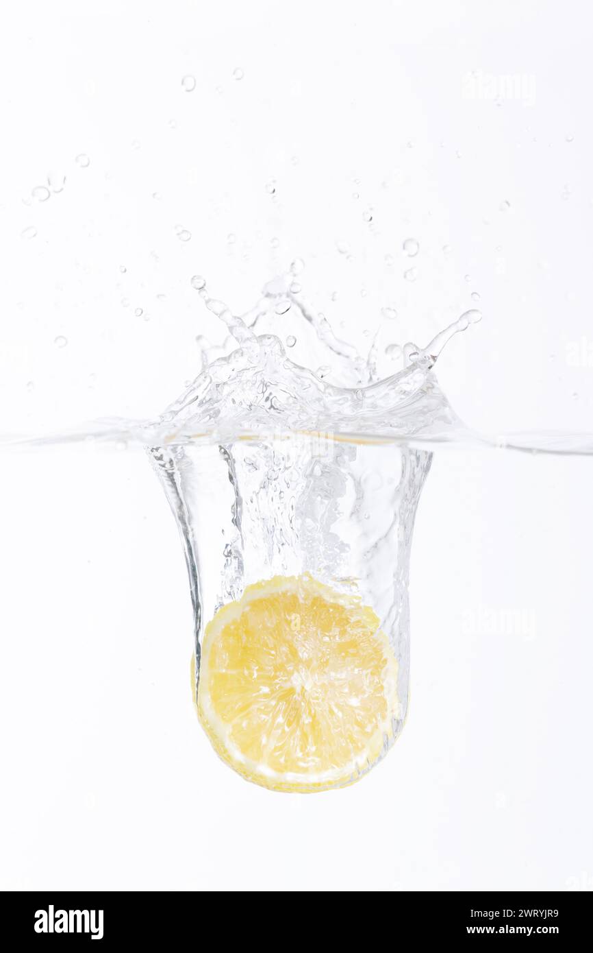 mezzo limone che cade in acqua Foto Stock