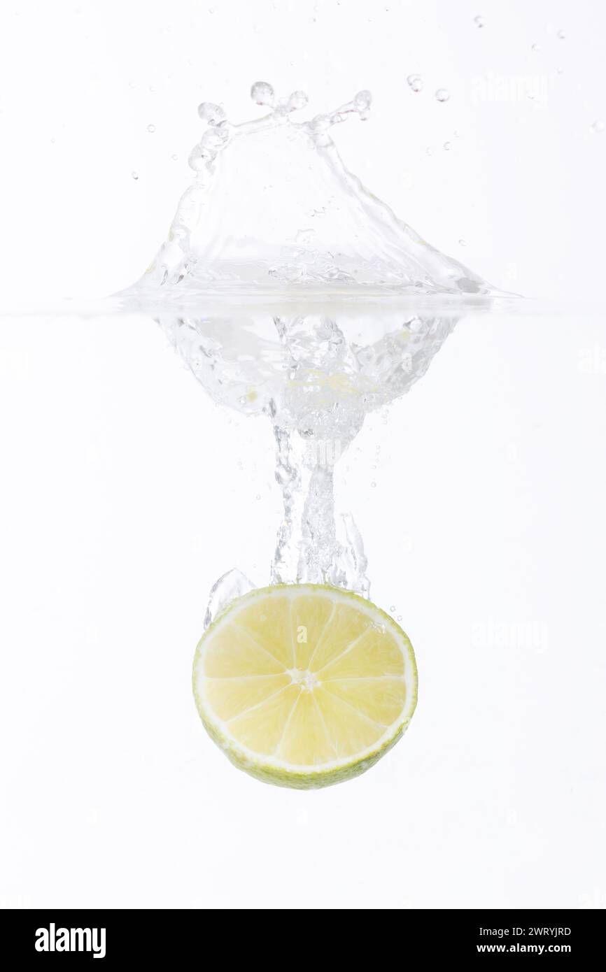 mezzo limone che cade in acqua Foto Stock