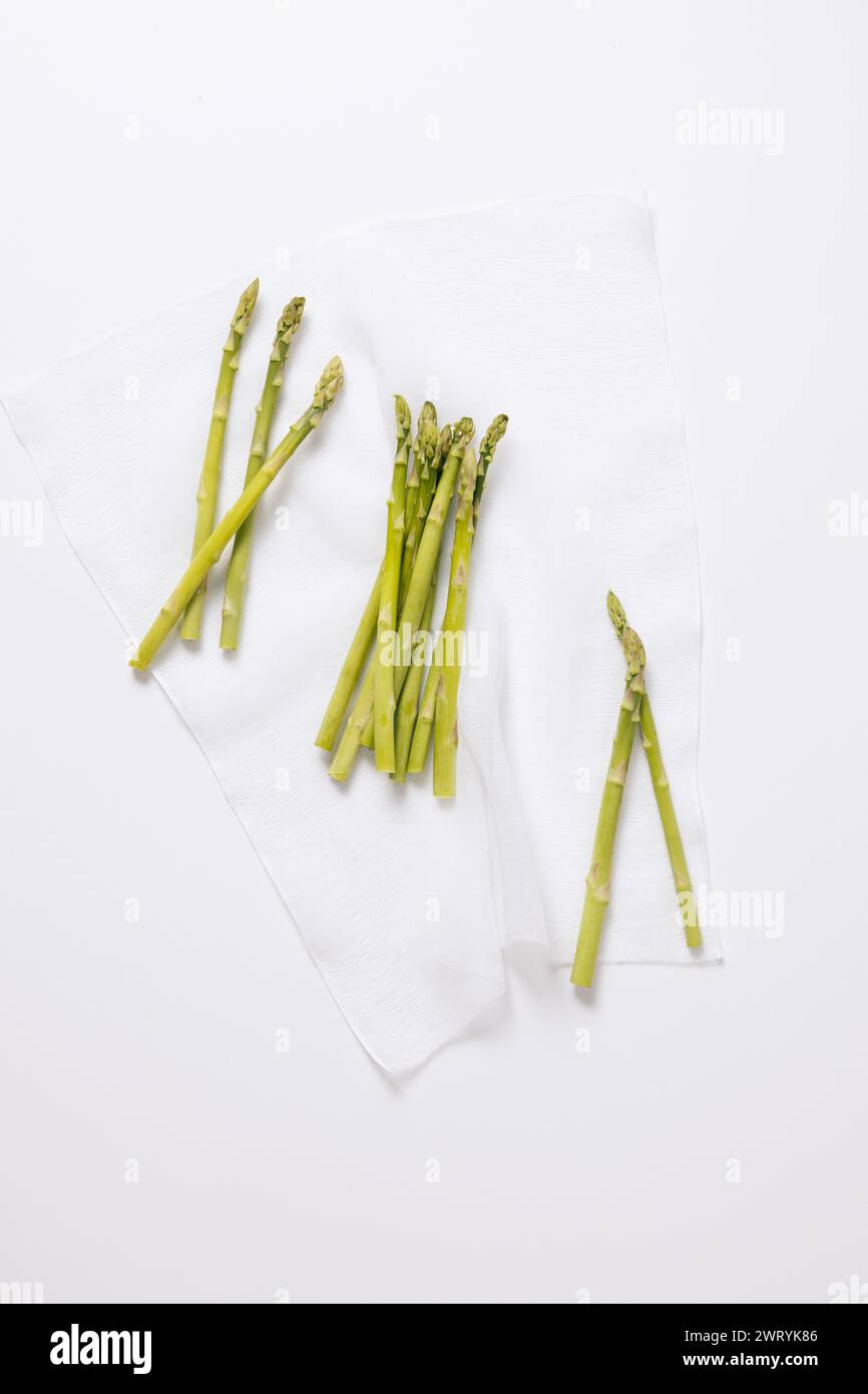 un mucchio di asparagi disposti su un panno bianco Foto Stock