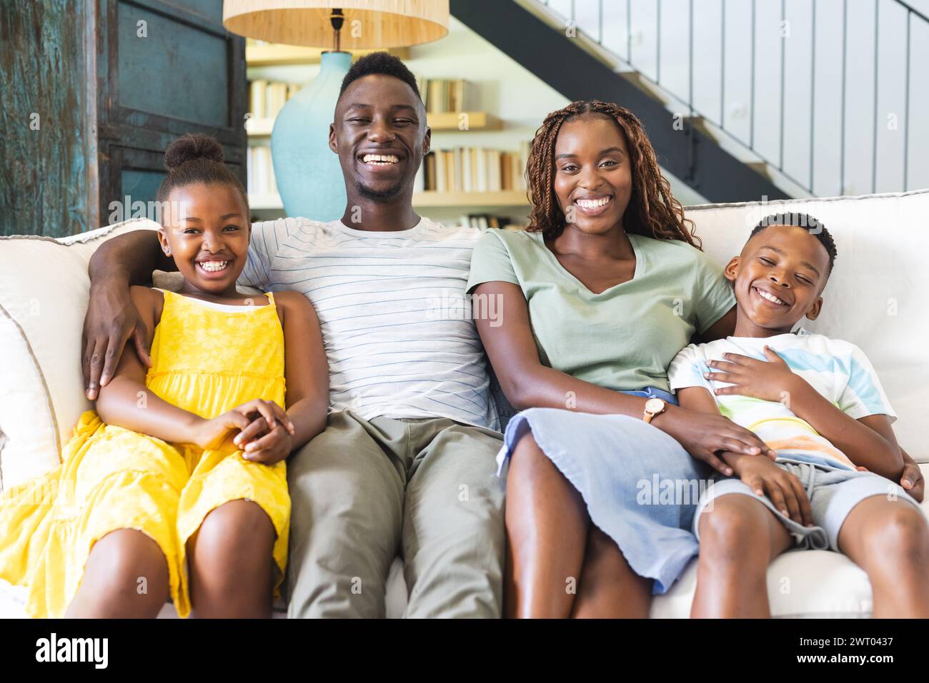 Una allegra famiglia afro-americana sta seduto da vicino su un divano a casa Foto Stock