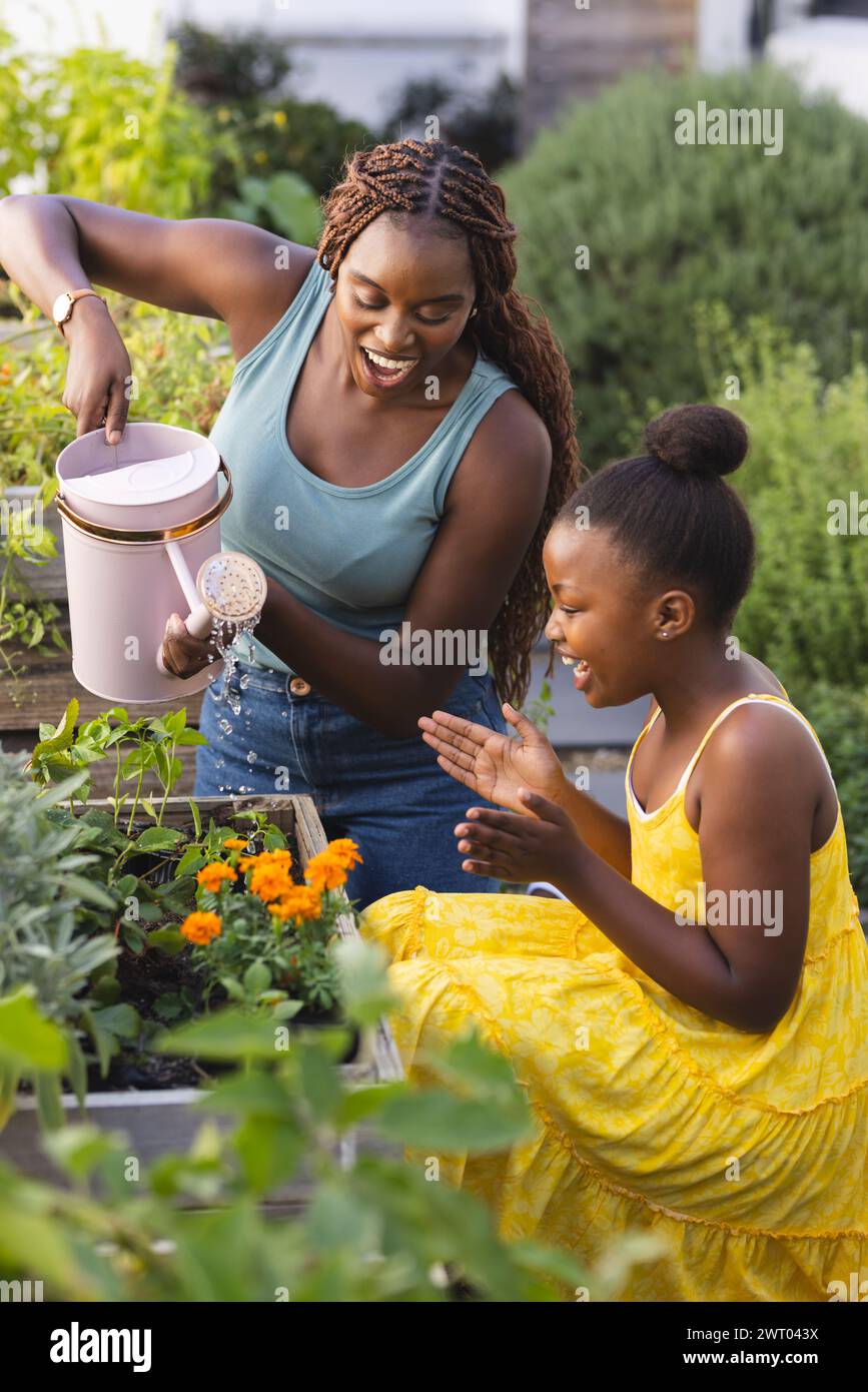 La madre e la figlia afroamericana amano fare giardinaggio insieme a casa Foto Stock