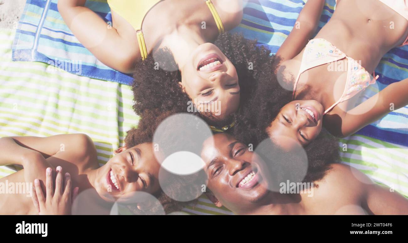 Immagine di punti luce sulla felice famiglia afroamericana in spiaggia Foto Stock