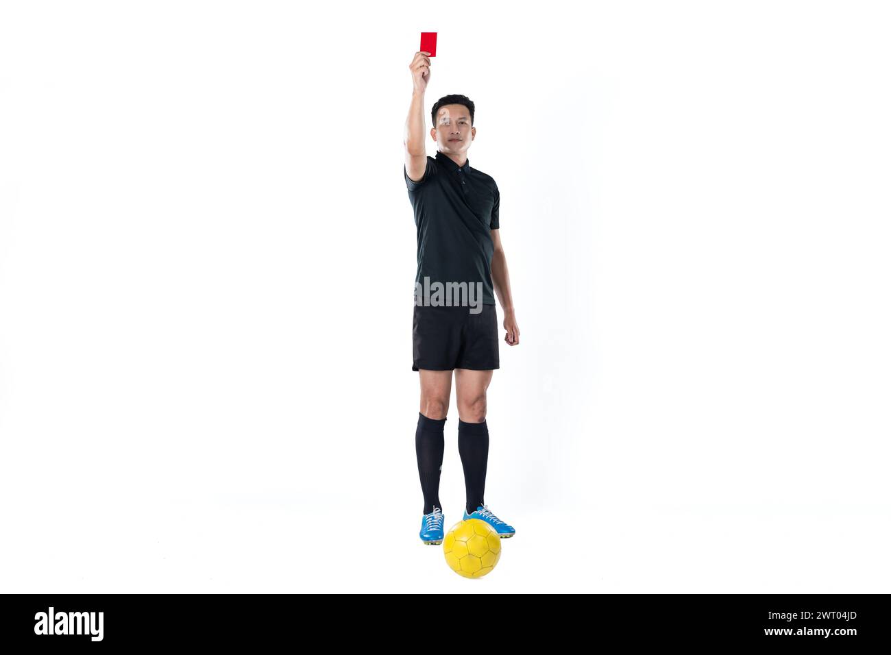Ritratto a figura intera di un arbitro di calcio che dà un cartellino rosso isolato su sfondo bianco. Foto Stock