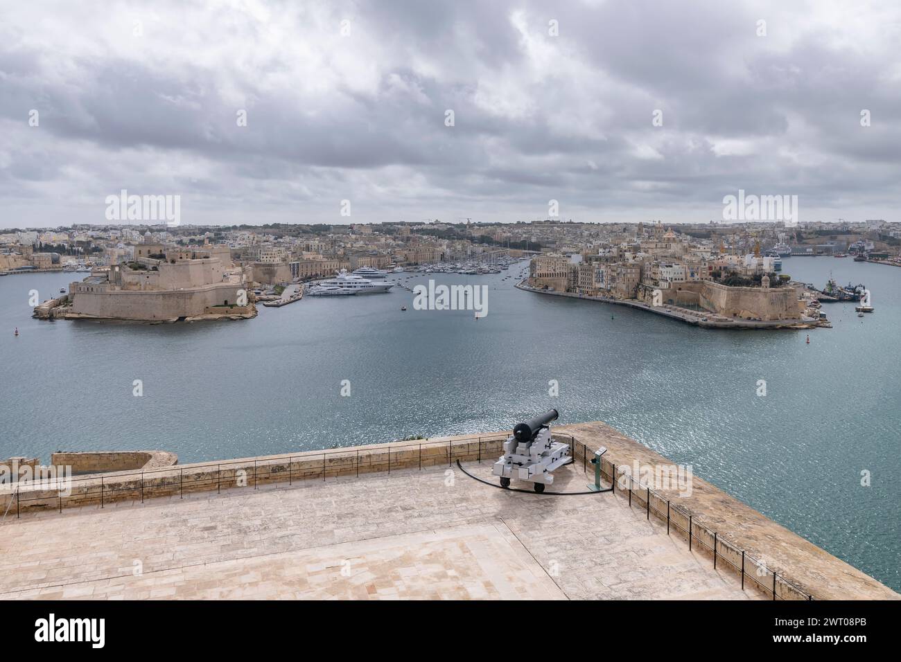 Un cannone è destinato alle tre città attraverso la baia di la Valletta, Malta Foto Stock