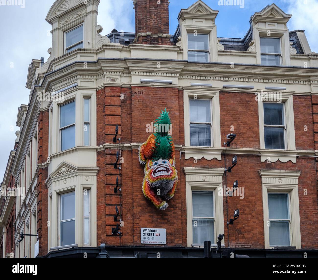 La scultura pubblica permanente The Lion di Tsai & Yoshikawa montata sul muro dell'edificio in Wardour St London è un simbolo cinese di saluto e tutela Foto Stock