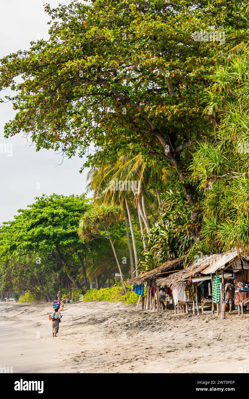 Mercante sulla spiaggia di Mangsit a Sengiggi, venditore, spiaggia di palme, viaggi, turismo, mare, spiaggia, acqua, palma, oceano, isola, costa, tropicale, tropicale Foto Stock