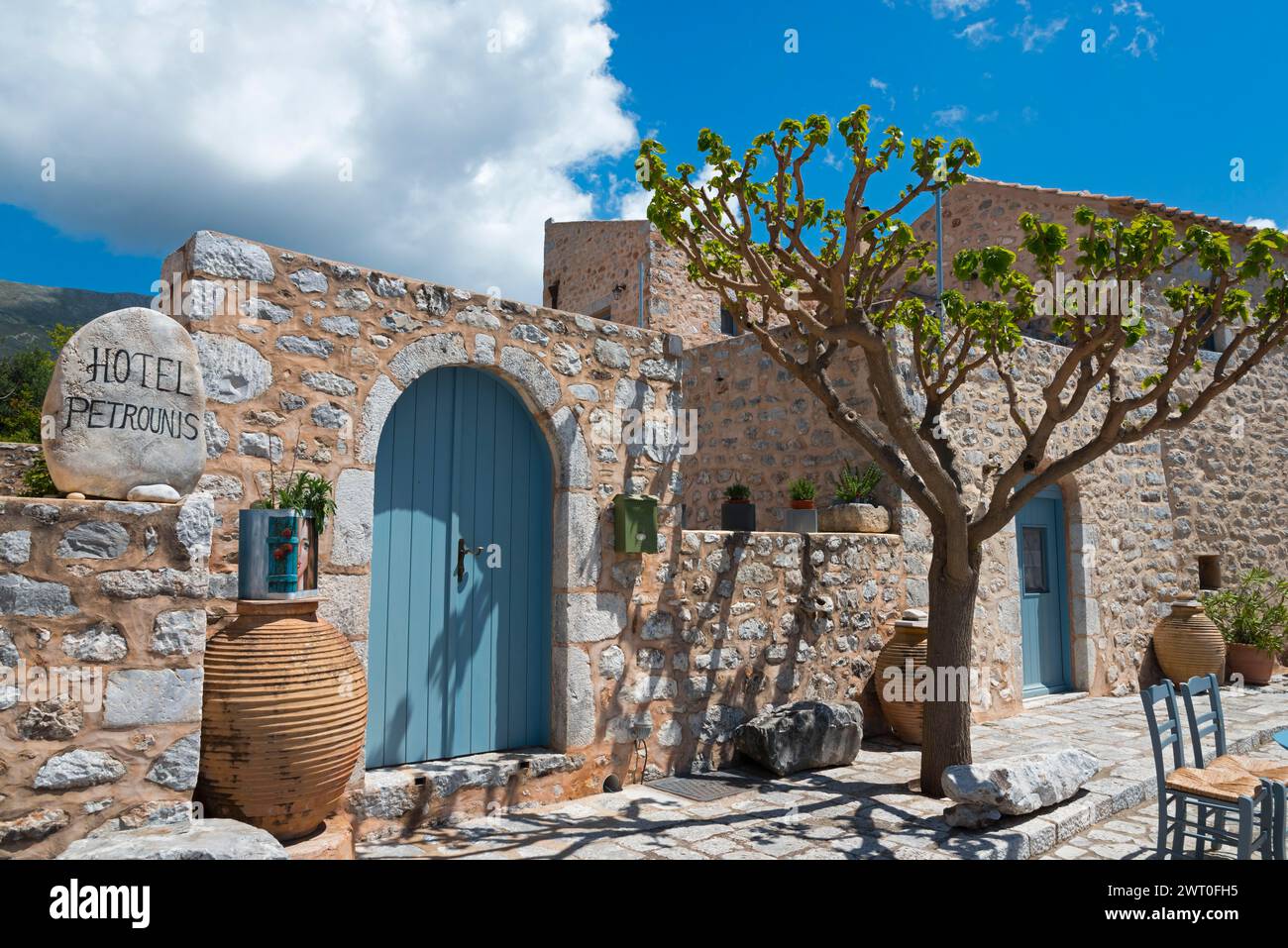 Hotel affascinante con facciata in pietra sotto un cielo blu limpido circondato da piante mediterranee, hotel tradizionale, Areopoli, Areopolis, Tsimova, Itylo Foto Stock