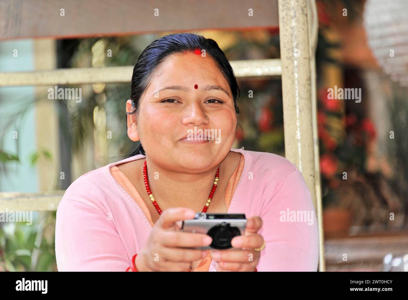 Una donna sorridente ha uno smartphone tra le mani, Pokhara Valley, Pokhara, Nepal Foto Stock