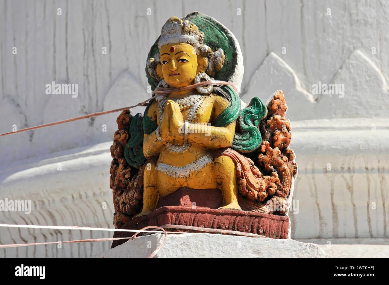 Colorata statua di Buddha in posa tradizionale con mani piegate, valle di Kathmandu, Nepal Foto Stock