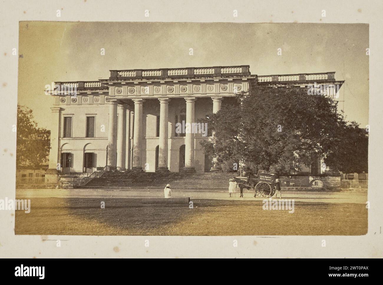 Municipio, Kolkata. Leon E. Douffet, fotografo (britannico, attivo negli anni '1860) Vista del Municipio degli anni '1870, un edificio neoclassico con portico dorico. Alcuni uomini possono essere visti di fronte all'edificio, la maggior parte dei quali sono vestiti con abiti tradizionali. Tre di loro si trovano accanto a un carro trainato da cavalli, decorato con "Léon Douffet Photo Artist". (Recto, monta) in basso a sinistra, sotto l'immagine, a matita: "[freccia verso l'alto] Léon Douffet / Photo Artist / (camera oscura portatile)"; Foto Stock