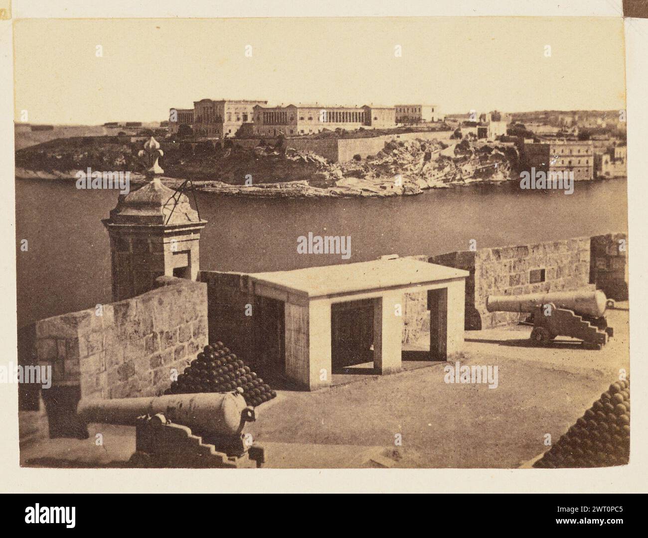 Royal Naval Hospital Bighi, Kalkara. Giorgio Sommer, fotografo (italiano, nato in Germania, 1834 - 1914) circa 1865 veduta a volo d'uccello del Royal Naval Hospital di Bighi, un complesso di edifici in stile dorico ai margini di una scogliera, come si vede dalla batteria salutista, un bastione militare. In primo piano sono visibili diversi canoni e palle di cannone. Foto Stock