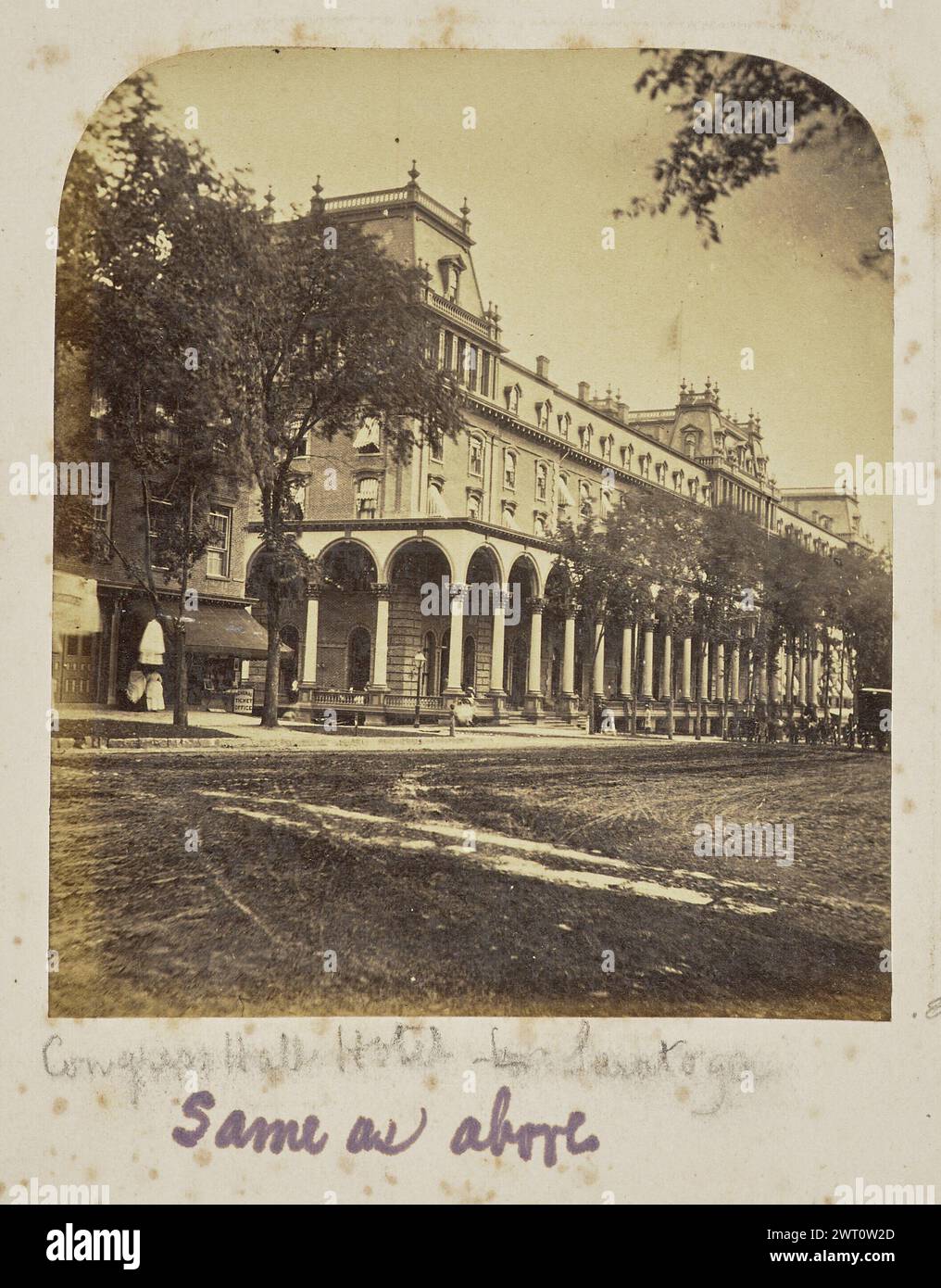 Congress Hall Hotel - Saratoga. Sconosciuto, fotografo 1867–1890 Vista esterna del Congress Hall Hotel, un edificio a più piani in stile architettonico del secondo Impero che è sormontato da tetti mansardati alle estremità e sezione centrale e presenta una galleria che si affaccia su una strada alberata. Accanto all'hotel si può vedere un negozio e un certo numero di persone sul marciapiede. (Recto, Mount) in basso a sinistra, sotto l'immagine, a matita: "Congress Hall Hotel - Saratoga"; in basso a sinistra, sotto l'immagine, in inchiostro viola: "Uguale a sopra"; Foto Stock