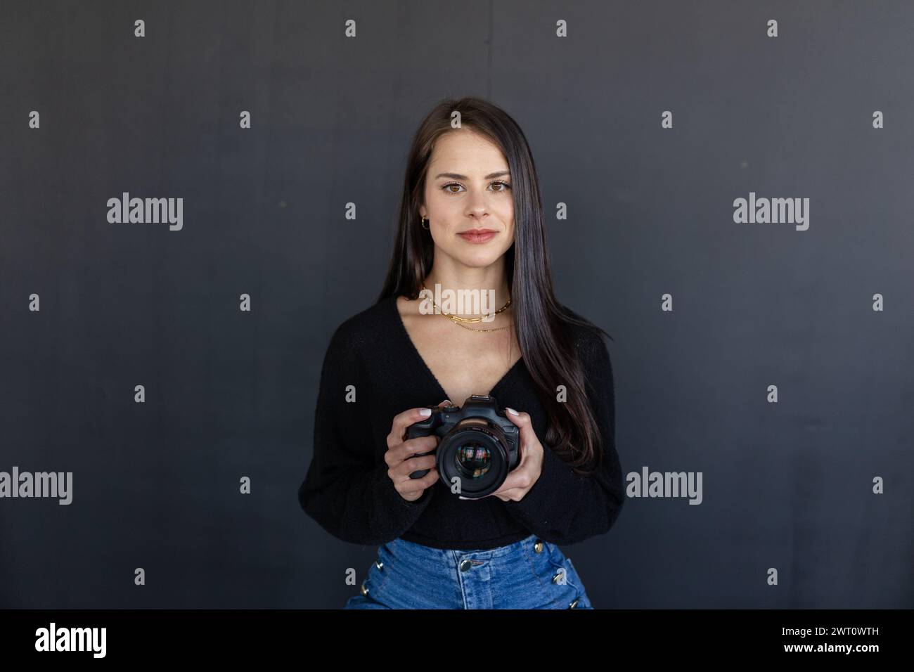 Fotografo con Canon su sfondo scuro. Foto Stock