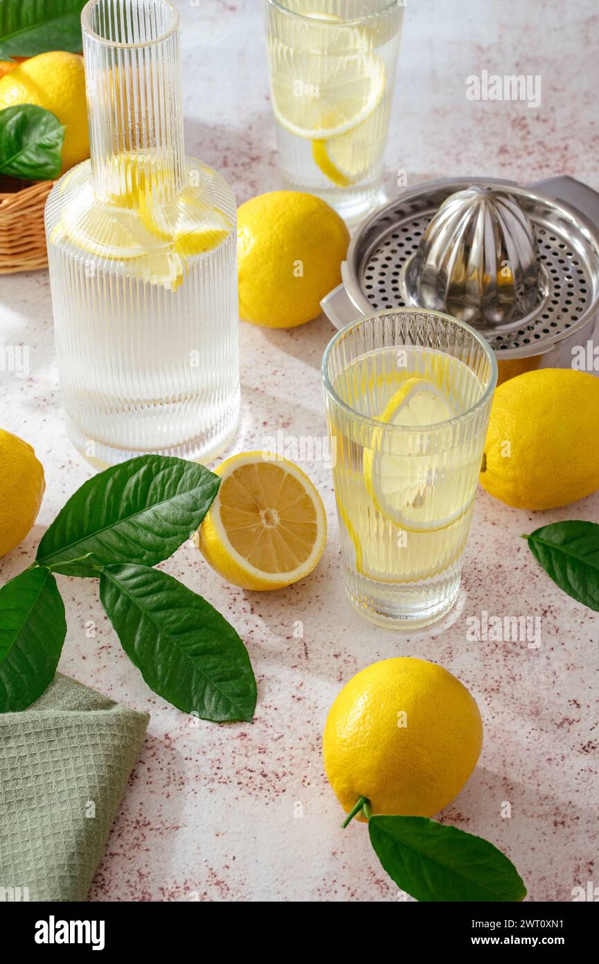 limonata estiva al limone in un bicchiere e decanter. I limoni sono scatte Foto Stock