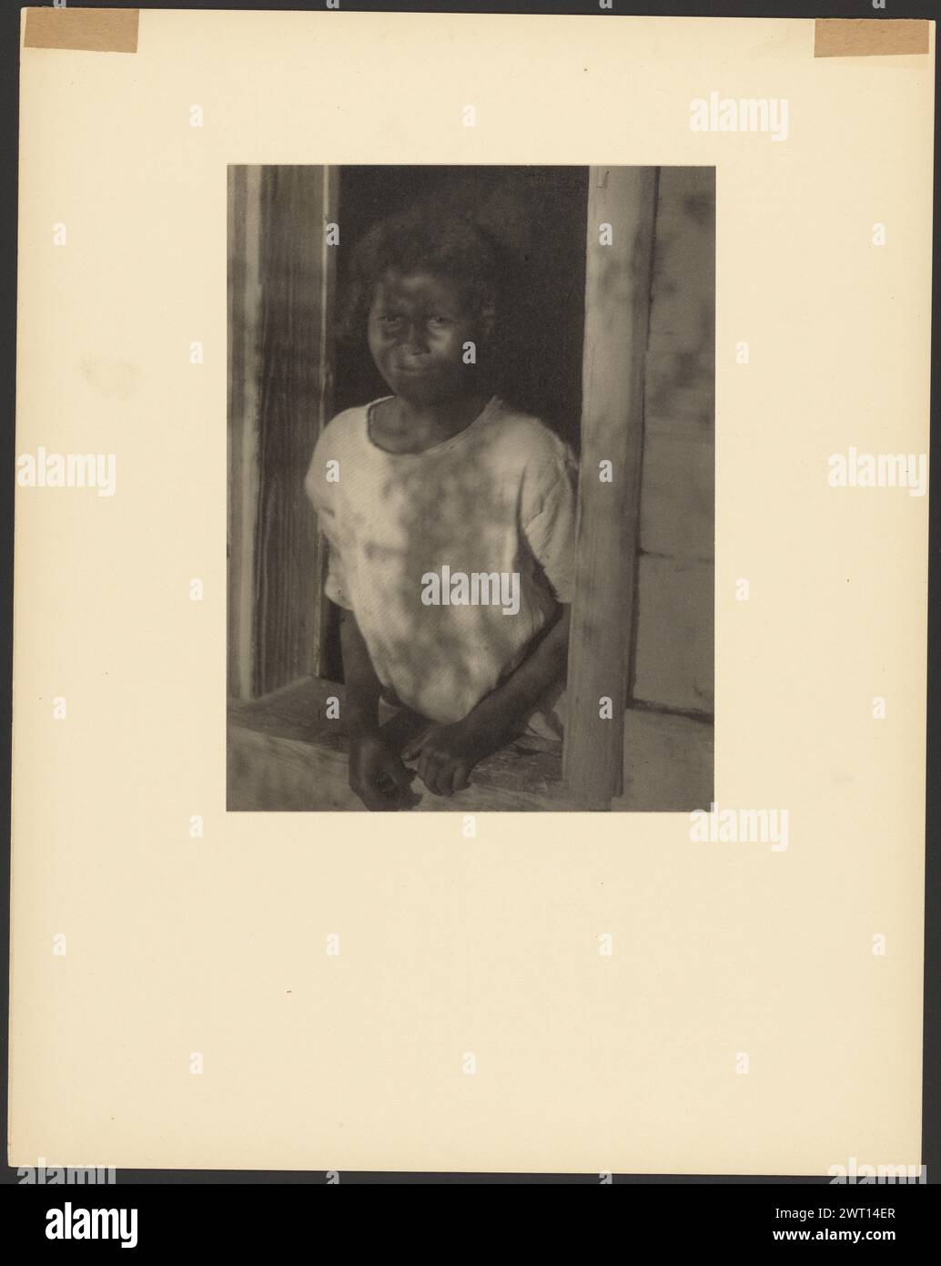 Young Black Girl incorniciata nella finestra. Doris Ulmann, fotografa (americana, 1882 - 1934) 1929–1930 Ritratto di una giovane ragazza nera frantumata in una finestra. Viene girata di tre quarti verso destra. Sta indossando una camicia bianca. Le sue mani poggiano sul davanzale. (Verso, Mount) in alto a sinistra, a matita rossa: "1264 [lateralmente]"; in basso a sinistra, in inchiostro verde: "134 [cerchiato]"; Foto Stock