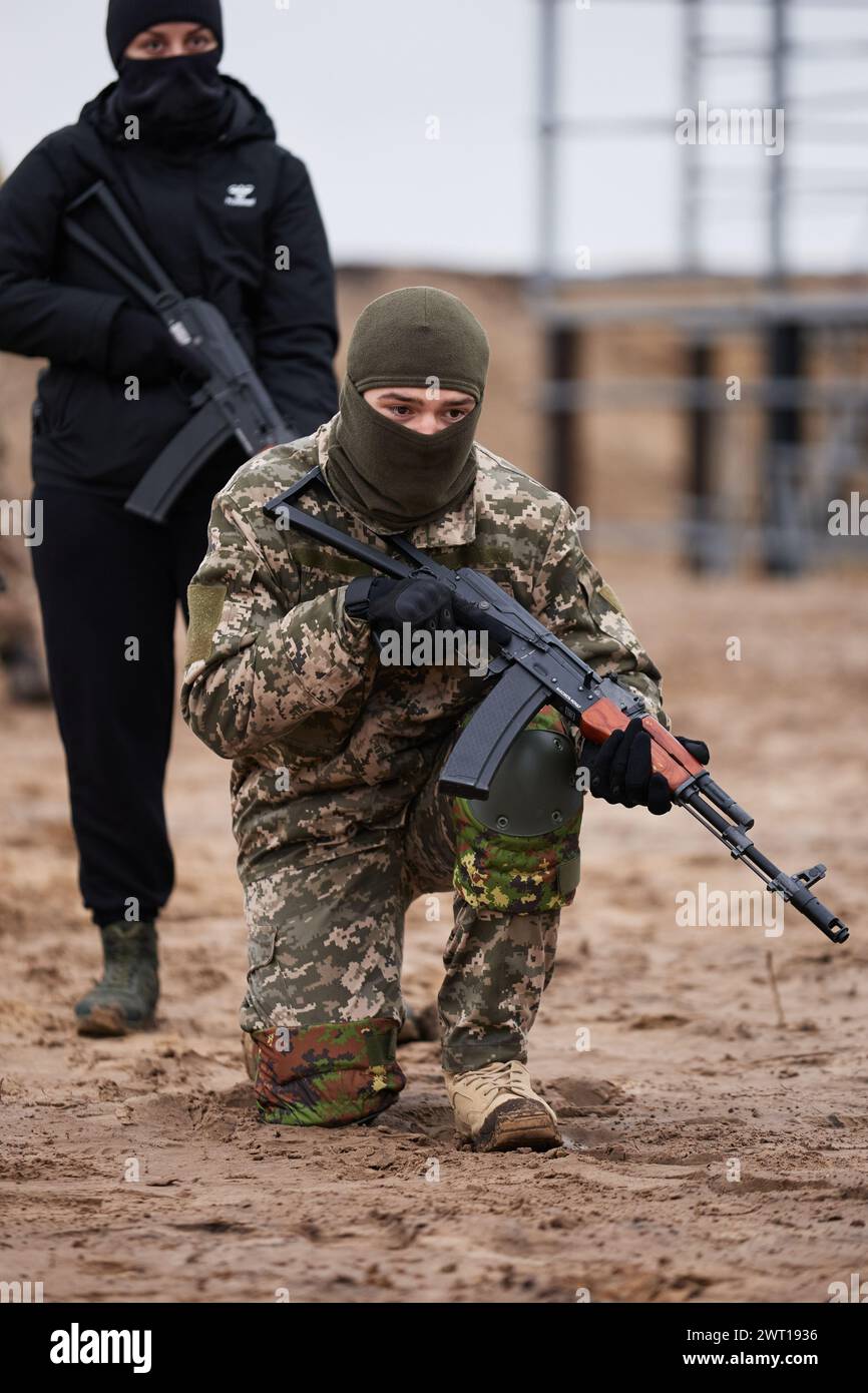Addestramento reclute ucraine con un'arma su un poligono militare. Giovane che pratica a mani il fucile. Kiev - 27 gennaio 2024 Foto Stock