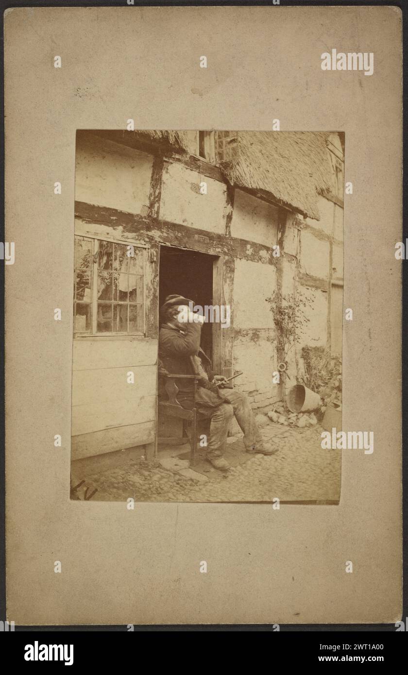 Uomo seduto che beve dalla tazza all'ingresso aperto. John Whistler, fotografo (britannico, 1830 - 1897) circa 1855-1865, Un uomo seduto su una sedia in una porta beve da una tazza. Foto Stock