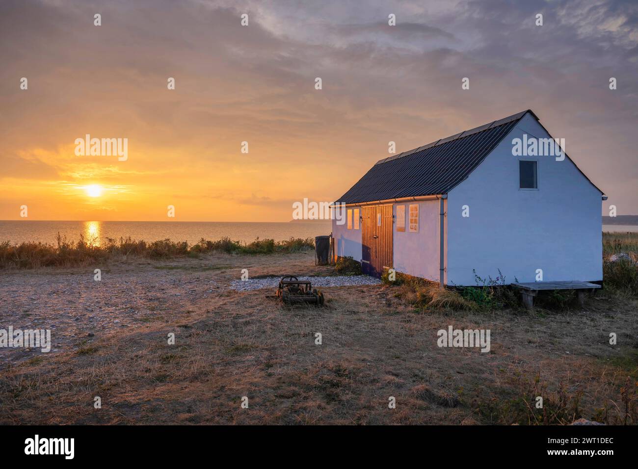 Casa di legno sulla costa del Mar Baltico al tramonto, Agernaes Havn, Danimarca, Helnaes Foto Stock