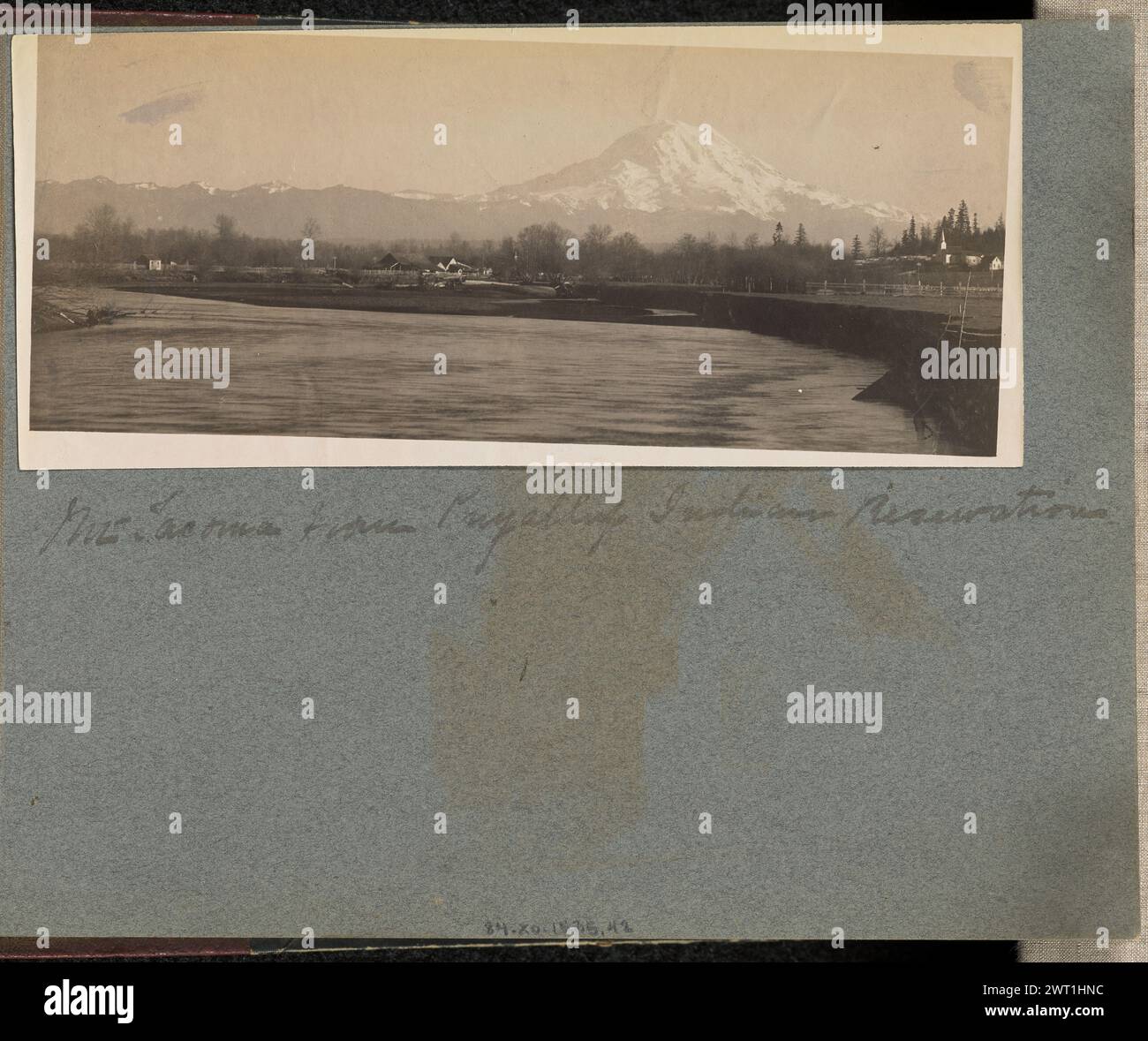 Monte Tacoma dalla riserva indiana di Puyallup. J.F. Ford, fotografo (americano, attivo negli anni '1900) circa 1900 vista distante del Monte Ranier, chiamato anche Monte Tacoma, dall'altro lato di un fiume, con fattorie, case e una chiesa nella riserva Puyallup visibile sparsa sullo sfondo. (Recto, montaggio) al centro, sotto la stampa, scritto a mano con inchiostro nero: "Mt. Tacoma dalla riserva indiana di Puyallup Foto Stock