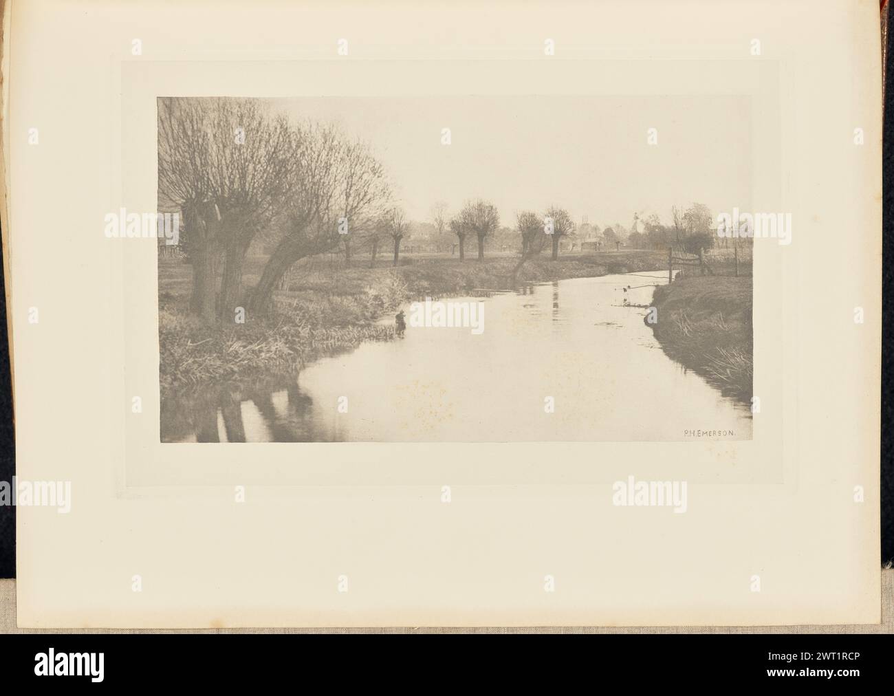 Stanstead della Lea. Peter Henry Emerson, fotografo (britannico, nato Cuba, 1856 - 1936) 1888 Vista del fiume Lea che attraversa Stanstead Abbotts. Una figura si trova nell'acqua poco profonda sul lato sinistro del fiume. Un piccolo cottage è visibile attraverso alberi di pollarded che crescono su entrambi i lati del fiume e attraverso il paesaggio. Il nome del fotografo, 'P.H. EMERSON', è stato graffiato nell'angolo inferiore destro dell'immagine. (Recto, adiacente interlacciamento) centrale, stampato con inchiostro nero: "PIASTRA VIII. STANSTEAD DELLA LEA. Foto Stock