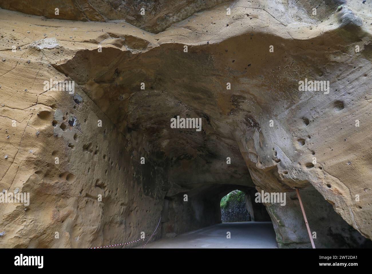 Il muro di tufo di fronte all'ingresso della grotta della Sibilla Cumana, sacerdotessa di Apollo, una delle più importanti Sibille, figure profetiche Foto Stock