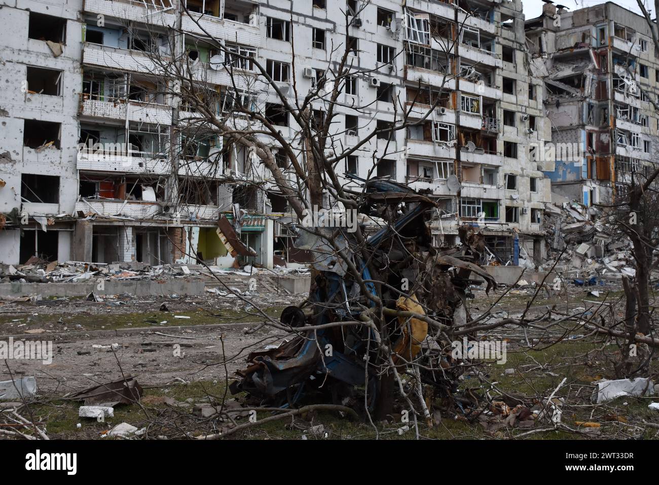 Un'auto distrutta è vista dall'edificio dell'appartamento che è stato pesantemente danneggiato dai bombardamenti russi a Orikhiv. Orikhiv è una piccola città nella regione di Zaporizhzhia, che funge da ultimo pilastro di resistenza per i soldati dell'esercito ucraino nel sud, mentre le forze armate russe continuano ad avanzare verso i Robotyne liberati. I cittadini di Orikhiv, che ospitano circa 700 persone, rischiano la vita a causa delle bombe aeree quotidiane e degli attacchi di artiglieria mentre lottano per sopravvivere. Foto Stock