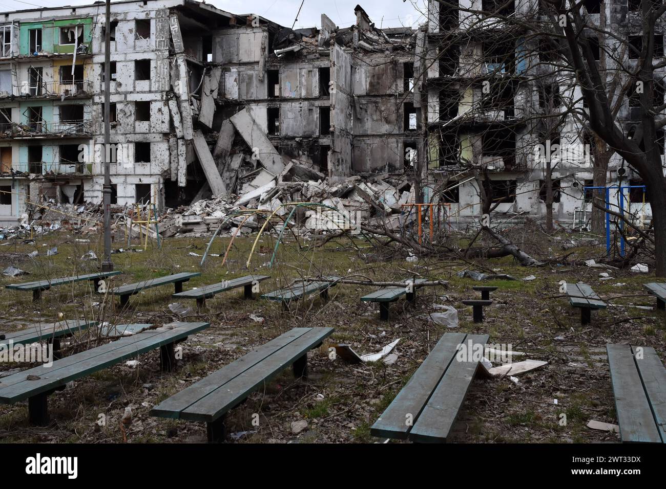 Una panchina di riposo è vista dagli edifici di appartamenti che sono stati pesantemente danneggiati dai bombardamenti russi a Orikhiv. Orikhiv è una piccola città nella regione di Zaporizhzhia, che funge da ultimo pilastro di resistenza per i soldati dell'esercito ucraino nel sud, mentre le forze armate russe continuano ad avanzare verso i Robotyne liberati. I cittadini di Orikhiv, che ospitano circa 700 persone, rischiano la vita a causa delle bombe aeree quotidiane e degli attacchi di artiglieria mentre lottano per sopravvivere. Foto Stock