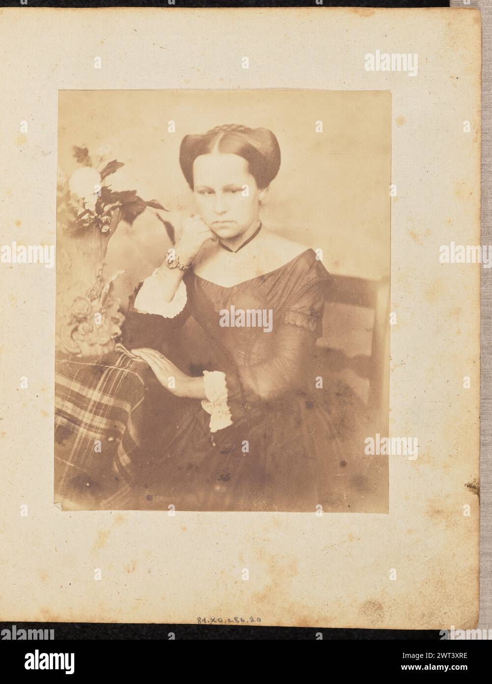 Ritratto di una donna. Jakob Höflinger, fotografo (svizzero, 1819 - 1898) intorno agli anni '1850 Ritratto di una donna seduta accanto ad un tavolo con un vaso di fiori in cima. Appoggia un gomito sul tavolo e appoggia delicatamente il mento sulla mano. Foto Stock