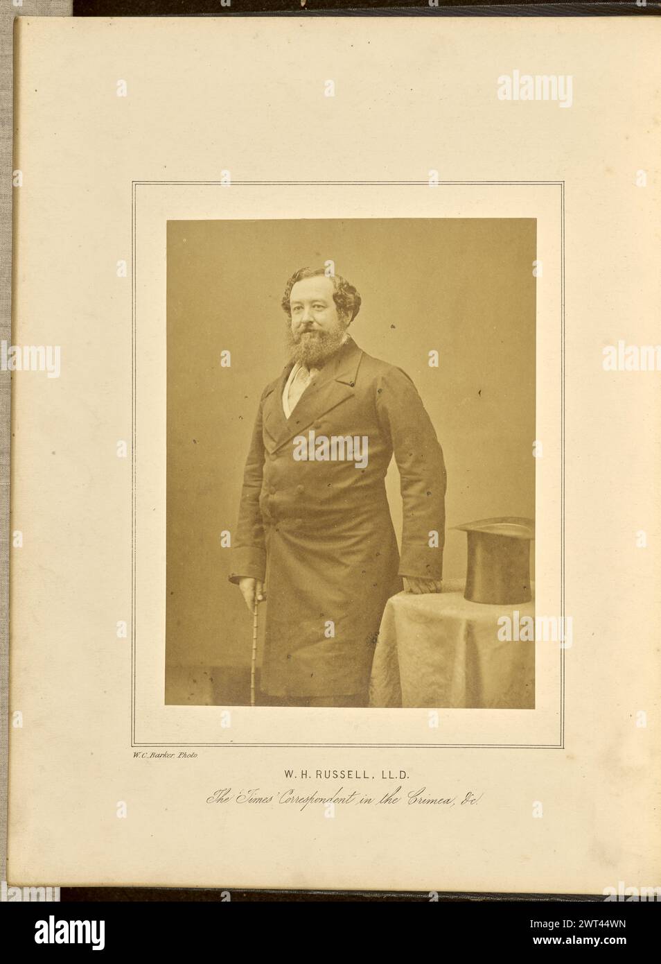 Ritratto di William H. Russell, LL.D.. W. C. Barker, fotografo (britannico, attivo negli anni '1860) 1859 Un ritratto di William Howard Russell, un reporter e corrispondente di guerra per il Times. Viene mostrato in piedi con una mano in un pugno, appoggiato su un tavolino. C'è un cappello sul tavolo accanto alla sua mano. Tiene un bastone con l'altra mano. (Recto, monta) in basso a sinistra, sotto l'immagine, lettera nera: "W.C. Barker, foto."; centro inferiore, sotto l'immagine, lettera nera: "W. H. RUSSELL, LL.D./The 'Times' corrispondente in Crimea, VC."; Foto Stock