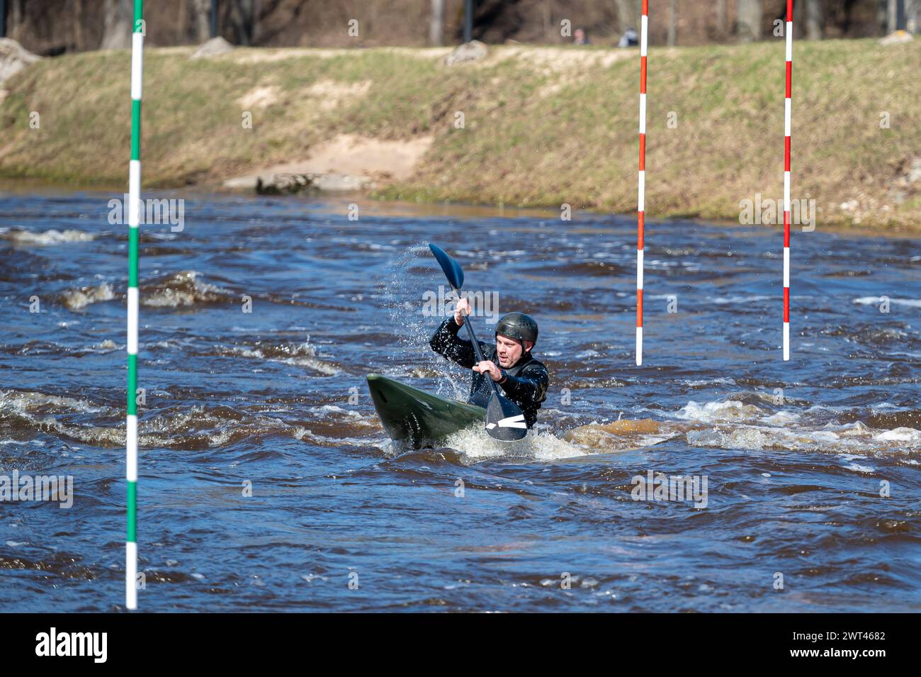 Valmiera, Lettonia - 9 aprile. 2023: Un uomo pratica kayak sulle rapide del fiume Gauja Foto Stock