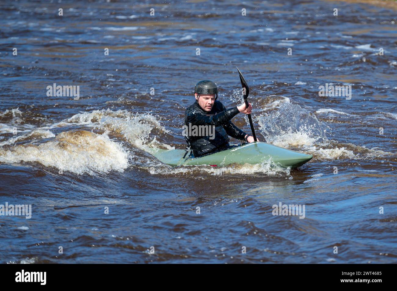 Valmiera, Lettonia - 9 aprile. 2023: Un uomo pratica kayak sulle rapide del fiume Gauja Foto Stock