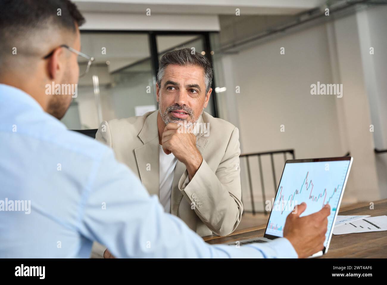 Consulente per un investitore azionario che mostra un piano di investimento su un laptop. Foto Stock