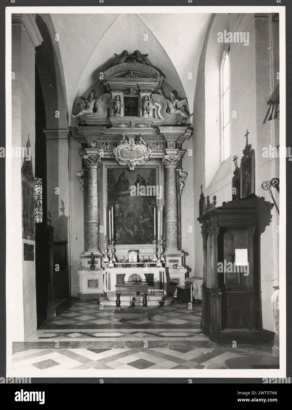 Umbria Perugia Spello S. Lorenzo5. Hutzel, Max 1960-1990 S. Lorenzo (1120) sorge sul sito dell'ex S. Ercolano. Vista esterna del portale (XIII secolo) e della facciata (rimodellata nel 1540). Le vedute interne si concentrano sulla pittura e la scultura (XV-XVIII secolo): Intarsia di marmo fonte battesimale (1607); baldacchino dell'altare maggiore (un'imitazione di quella di San Pietro, Roma); coro in legno di intarsia; armadio e cassa in legno nella Sacrestia con la figura intarsiata di Mosè, Noè e Zaccaria; pulpito in legno con bassorilievi del Martirio di S. Lorenzo; affreschi nella C neoclassica Foto Stock