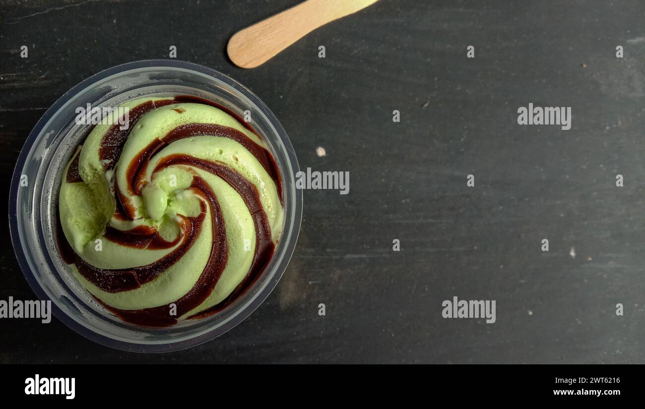 La foto è una foto di gelato al gusto di avocado in una tazza con sfondo nero Foto Stock