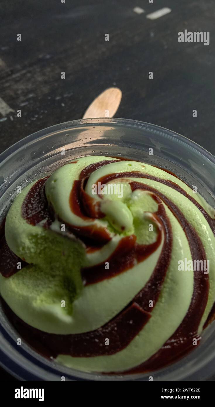 La foto è una foto di gelato al gusto di avocado in una tazza con sfondo nero Foto Stock