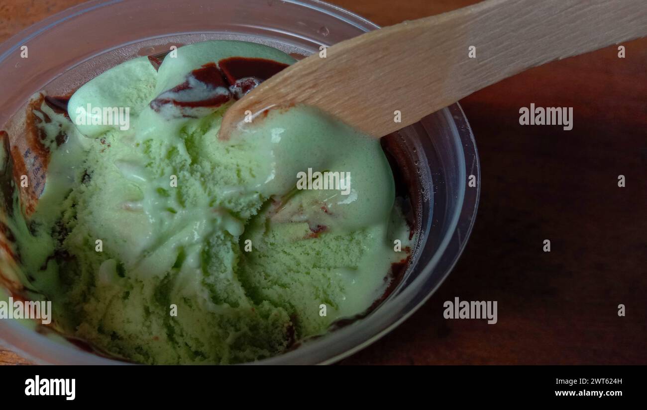 La foto è una foto di gelato al gusto di avocado in una tazza con sfondo nero Foto Stock
